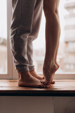 couple at home, legs close-up, a girl steps on a guy's feet, love, relationship, hugs