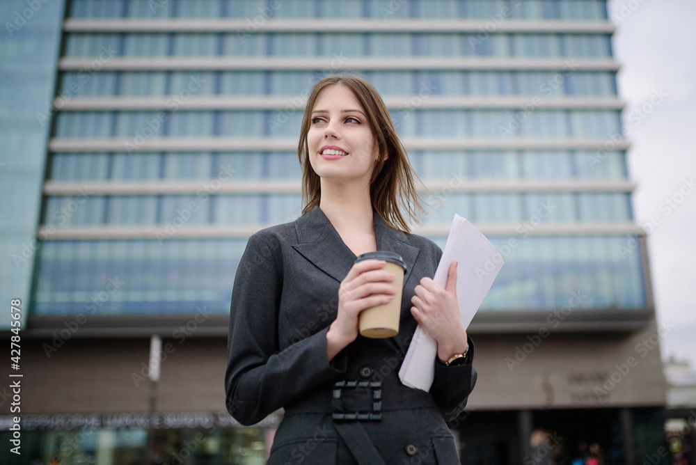 Business lady stands in front of the business center Business lady stands in front of the business center
