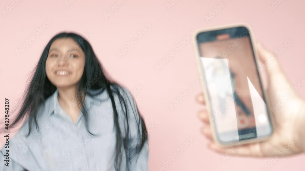 Young teenage hispanic latin girl dancing and shooting recording a video on smartphone camera. Modern trends on internet among young people Young teenage hispanic latin girl dancing and shooting recording a video on smartphone camera. Modern trends on internet among young people
