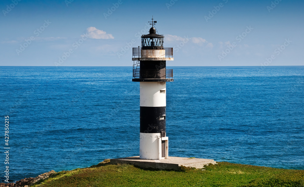 View of the Pancha Island Lighthouse in Ribadeo, Galicia. With the blue sea in the background.