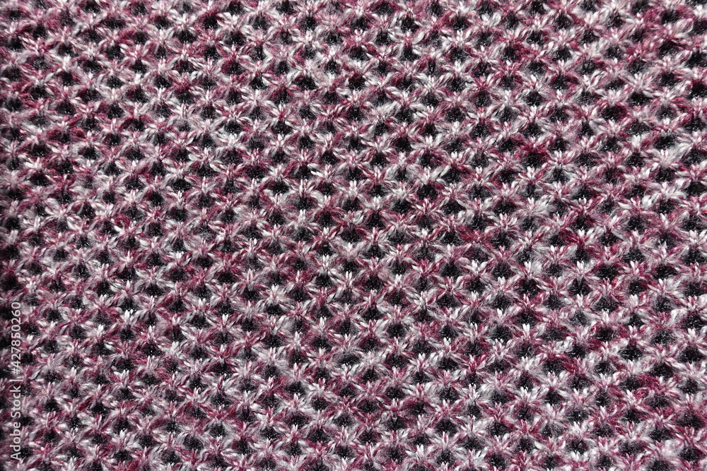 View of thick pink, grey and white woolen fabric with diamonds pattern from above View of thick pink, grey and white woolen fabric with diamonds pattern from above