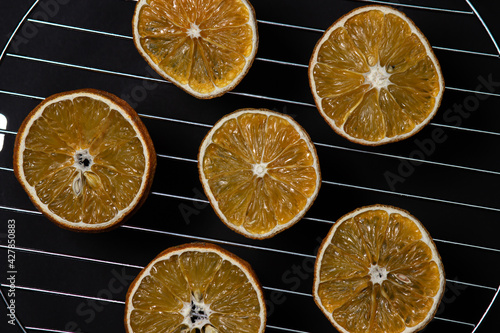 Dried orange slices on a black background. Dried orange on a dark background. Dried fruit.