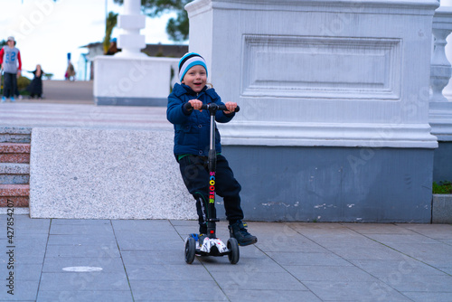 Batumi, Georgia - March 15, 2021: A boy riding a scooter downhill