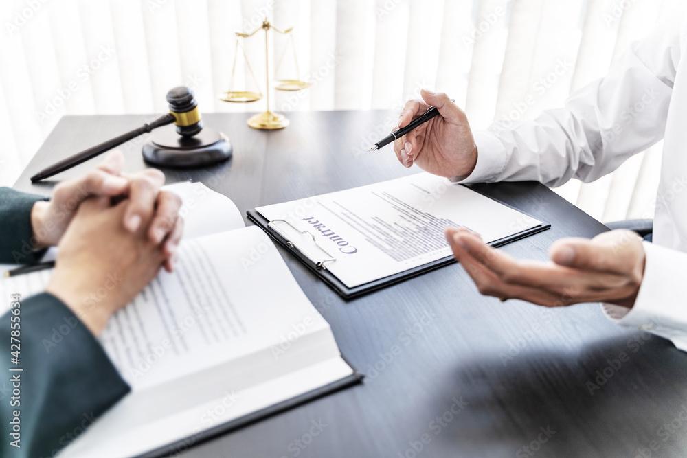 Lawyer preparing to sign a contract reading documents at meeting Lawyer preparing to sign a contract reading documents at meeting