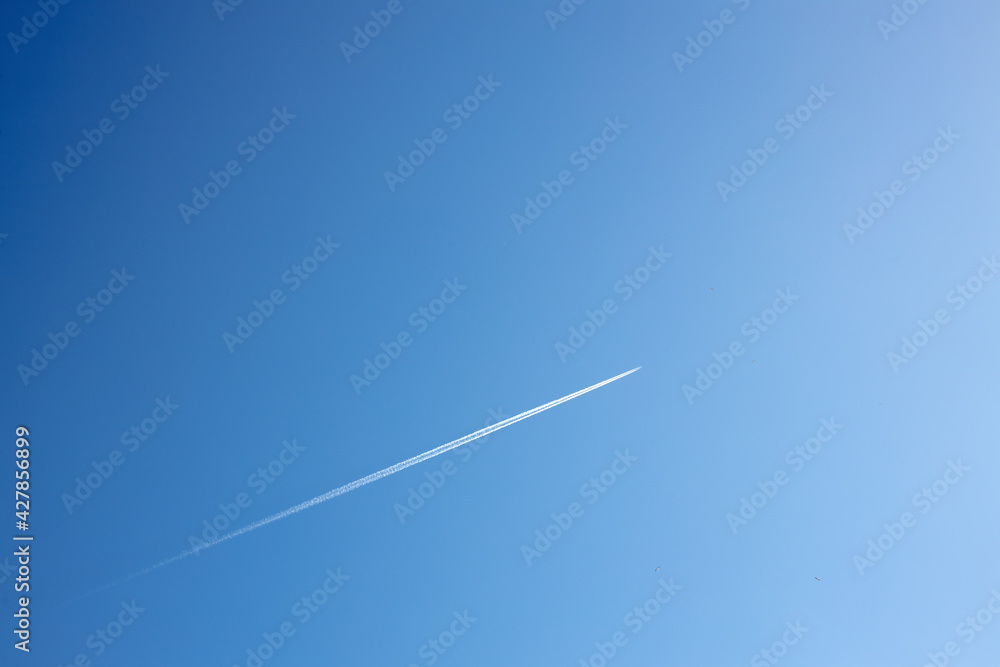 fighter in flight in the air, white reversing trail of the aircraft in the blue sky, a supersonic fighter in flight fighter in flight in the air, white reversing trail of the aircraft in the blue sky, a supersonic fighter in flight