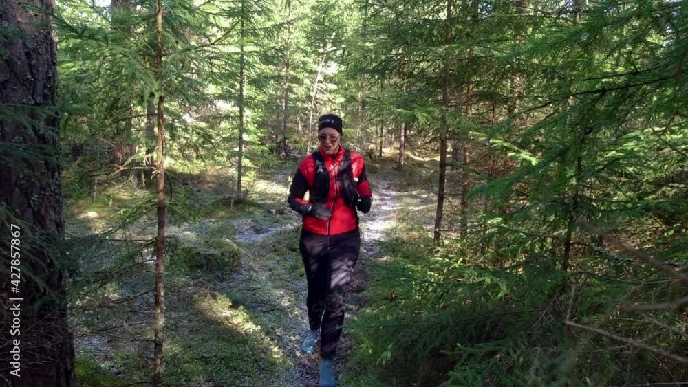 Female Trailrunner Running Down a Forest Single Track. Talent running towards the camera. Female Trailrunner Running Down a Forest Single Track. Talent running towards the camera.