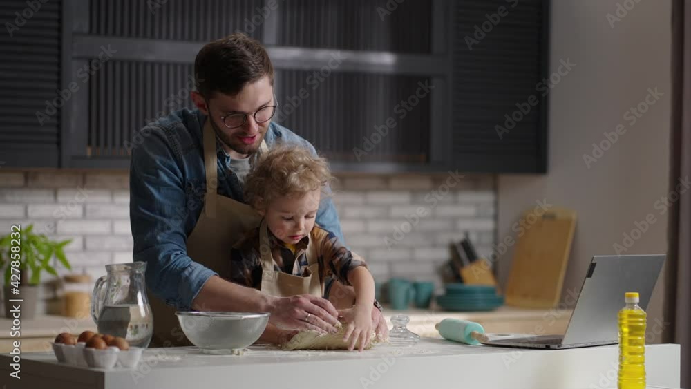 dad and toddler are kneading dough on kitchen table, cooking together at weekend, father is spending time with his child dad and toddler are kneading dough on kitchen table, cooking together at weekend, father is spending time with his child