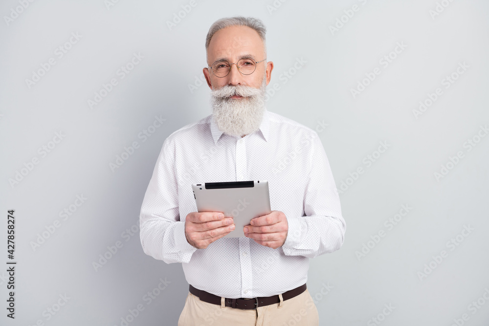 Photo of handsome strict grey hair old man hold tablet wear spectacles shirt isolated on grey color background