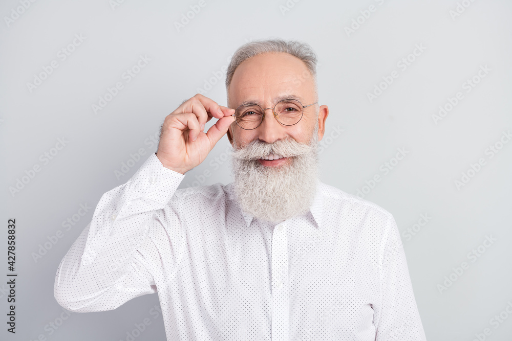 Fototapeta premium Photo of handsome cheerful grey hair old man touch spectacles wear white shirt isolated on grey color background