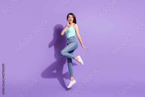 Full size photo of young charming pretty excited smiling cheerful girl jumping isolated on purple color background