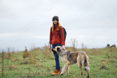 woman hiker with a backpack in nature walks the dog in the mountains friendship travel © SHOTPRIME STUDIO