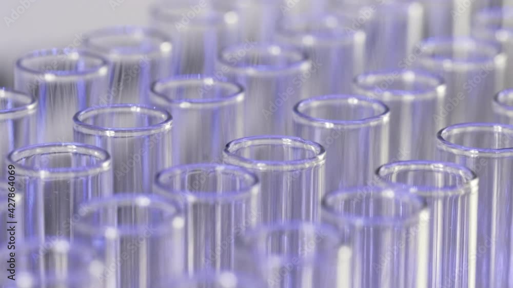 Rows of clean medical glass tubes illuminated in blue. The camera moves slowly along the tracks. Rows of clean medical glass tubes illuminated in blue. The camera moves slowly along the tracks.