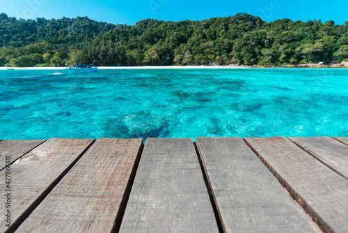 Wooden floor or plank on blurred background of the sea in summer. For product display.Calm Sea and Blue Sky Background.