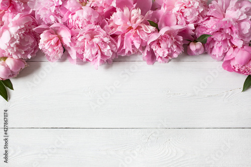 Fototapeta Naklejka Na Ścianę i Meble -  Pink peonies on a white wooden background, space for congratulations text.