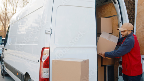delivery men unloading cardboard boxes from truck on street. High quality photo