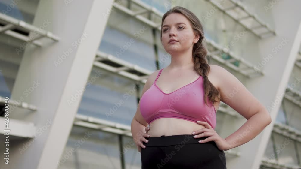 Active plump woman standing at the stadium, jogging in the morning, weight loss Active plump woman standing at the stadium, jogging in the morning, weight loss