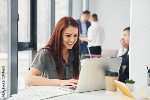 Woman in front of her colleagues. Group of people in official formal clothes that is indoors in the office