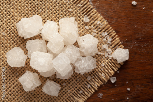 Φωτογραφία Close-up of coarse sea Salt (sodium chloride) edible on the wooden top background and jute mat