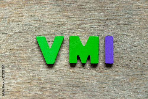 Color alphabet letter in word VMI (abbreviation of vendor managed inventory) on wood background