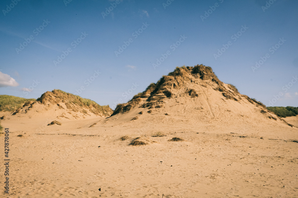 Rocky sand dunes against a blue sky