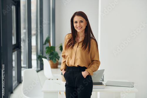 Obraz na plátně Woman in formal clothes is indoors in the modern office at daytime