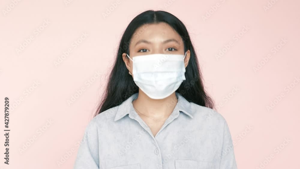 Asian or hispanic young pretty woman putting on face mask against virus bacteria prevention outbreak during coronavirus pandemic Asian or hispanic young pretty woman putting on face mask against virus bacteria prevention outbreak during coronavirus pandemic