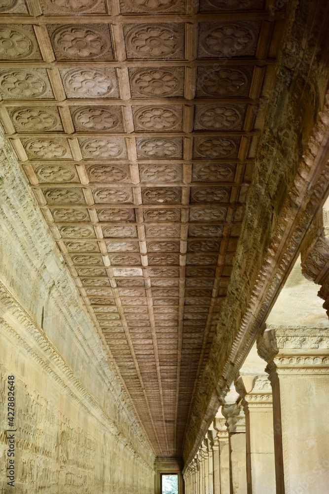 Old temple hallway with pillars and carved ceiling