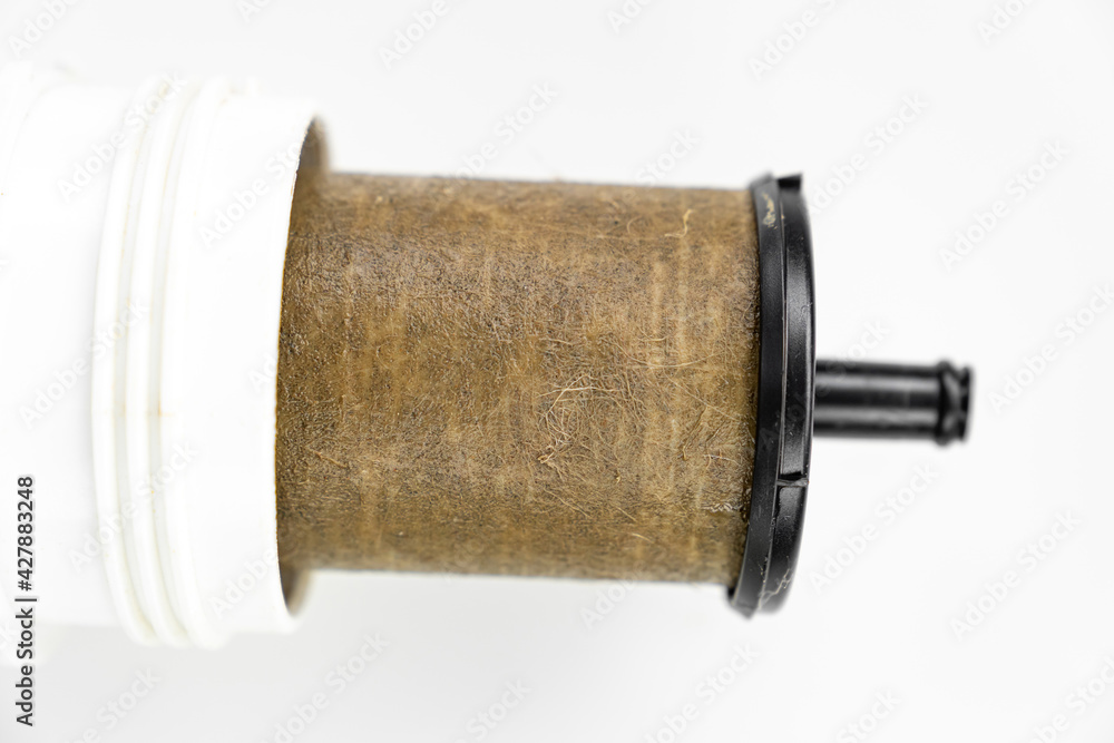 Dirty filter cartridge drinking water on a white background. Replacing cartridges is a mandatory procedure that must be carried out to maintain quality water purification. Pollution.