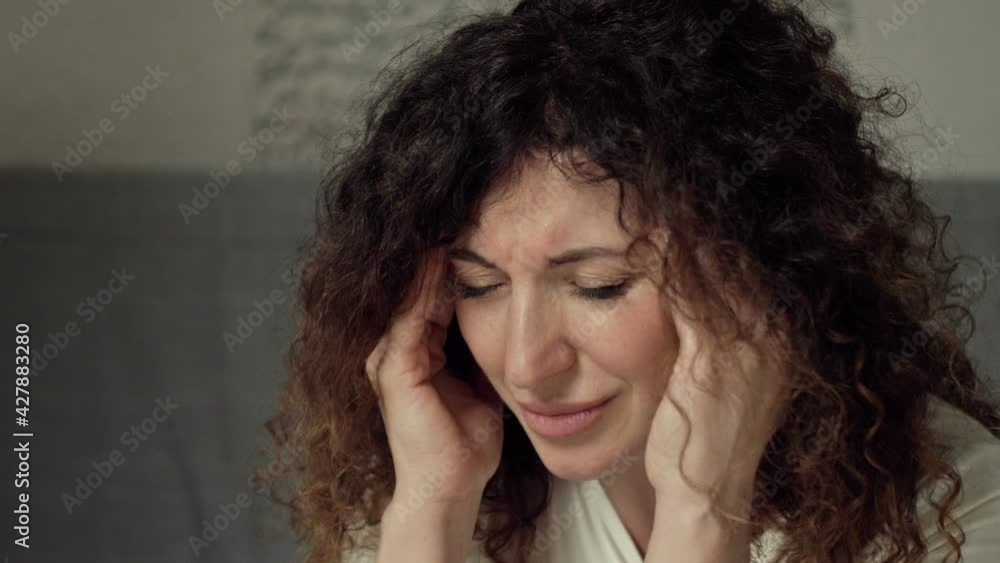 Portrait of a middle-aged woman suffering from severe headache. Migraine symptoms. Portrait of a middle-aged woman suffering from severe headache. Migraine symptoms.