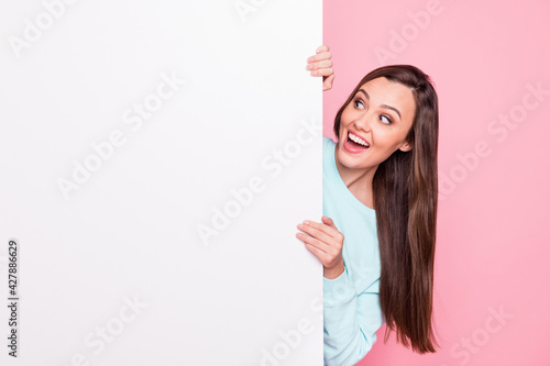 Fotografia Photo of pretty surprised young woman look stand behind blank white board empty