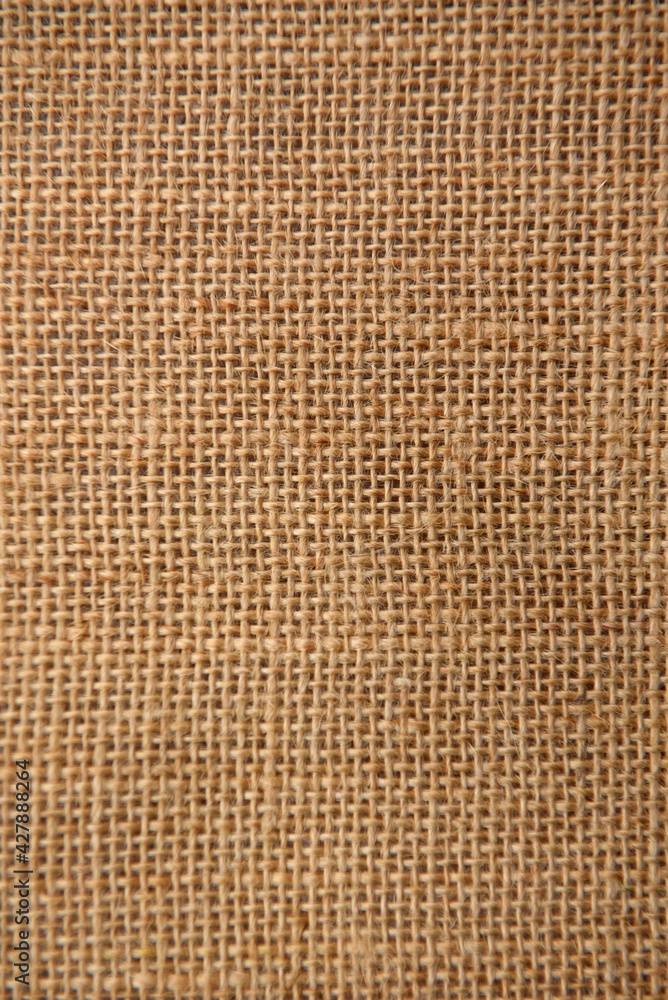 Texture background of the surface of brown burlap woven in a cage of coarse threads Texture background of the surface of brown burlap woven in a cage of coarse threads