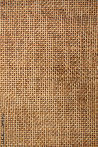 Texture background of the surface of brown burlap woven in a cage of coarse threads