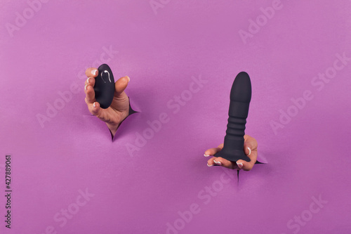 Black silicone sex toys on a pink background. Erotic toy for fun. Sex gadget and masturbation device. Place for text. Sex shop concept. Dildo, anal butt plugs, vibrators, vaginal balls. photo