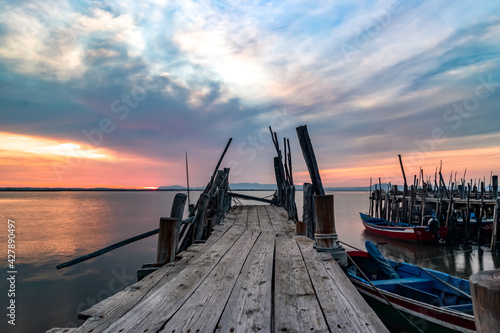 Spectacular sunset at the Carrasqueira Palafitic pier in Comporta, Portugal. Panoramic photo