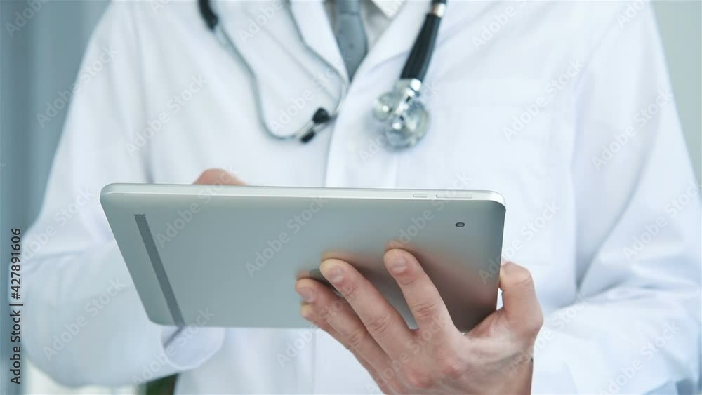 Doctor With Digital Tablet In Hands And Surfing Medical Information. Healthcare And Medicine Concept. Doctor With Digital Tablet In Hands And Surfing Medical Information. Healthcare And Medicine Concept.