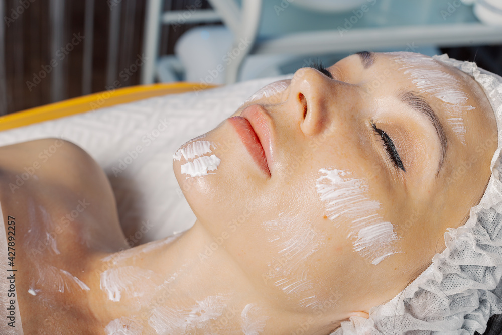 Beautiful young woman with cream mask on face. Beautiful young woman with cream mask on face.