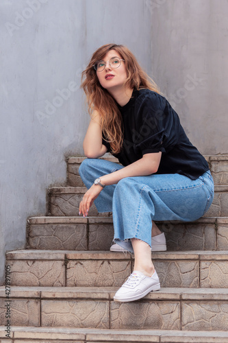 Girl with beautiful hair on the stairs in summer