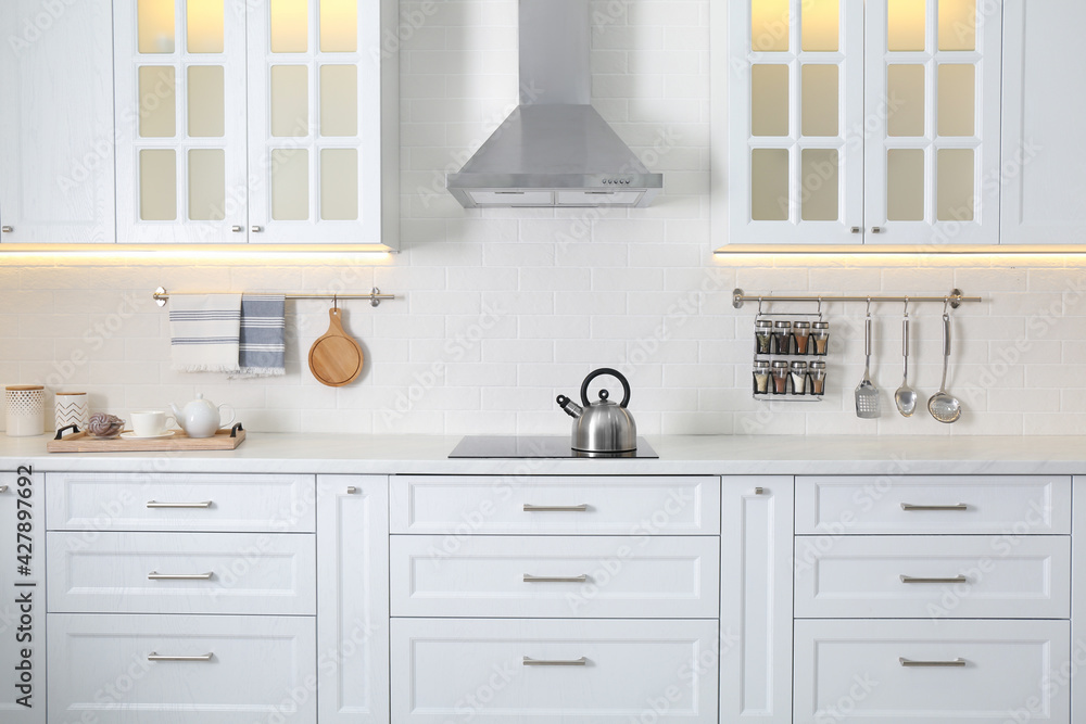 Fototapeta premium Elegant kitchen interior with modern stove and stylish furniture