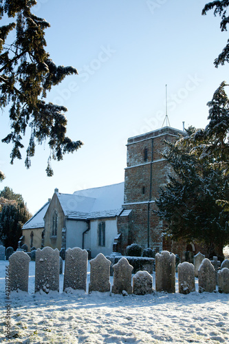 An old church and row of gravestones in the snow