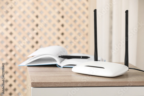 Modern Wi-Fi router indoors. Space for text