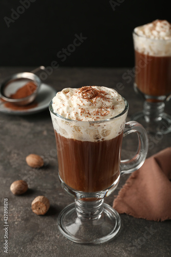 Hot drink with nutmeg powder on grey table