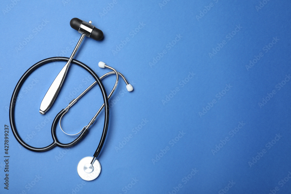 Reflex hammer, stethoscope and space for text on blue background, flat lay. Nervous system diagnostic Reflex hammer, stethoscope and space for text on blue background, flat lay. Nervous system diagnostic