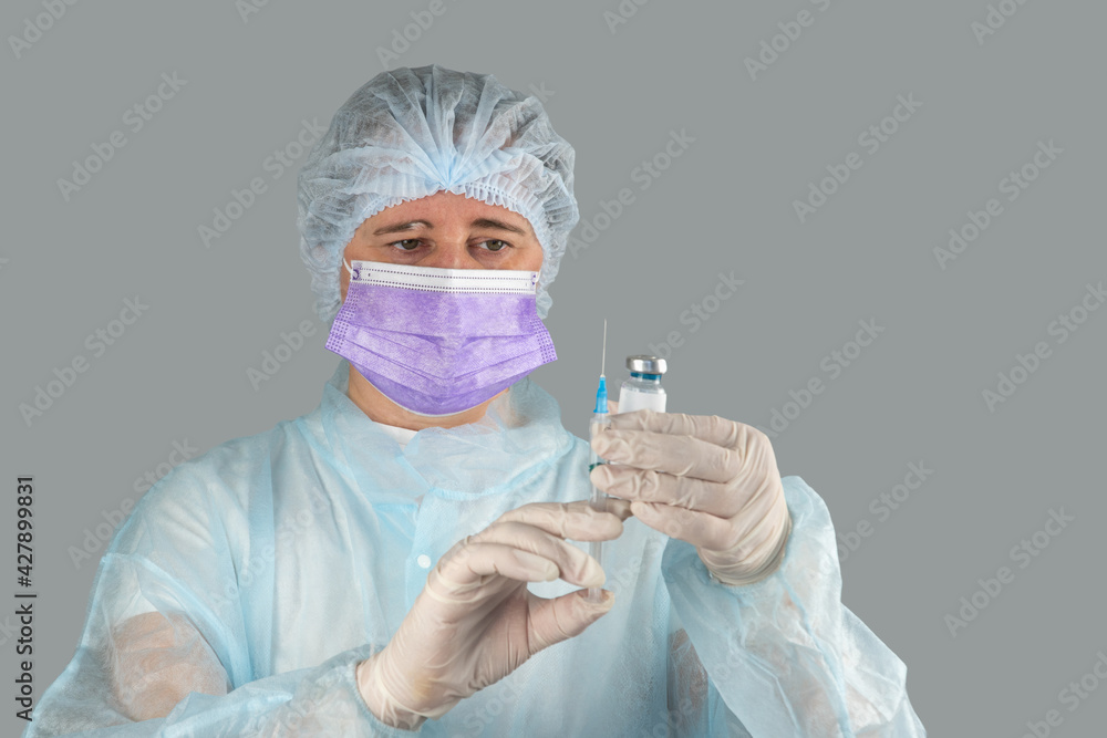 nurse with a syringe in her hand and an ampoule with a vaccine against a viral disease nurse with a syringe in her hand and an ampoule with a vaccine against a viral disease