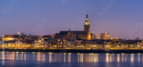 Evening skyline Nijmegen during blue hour, with the lights reflecting on the Waal river. photo