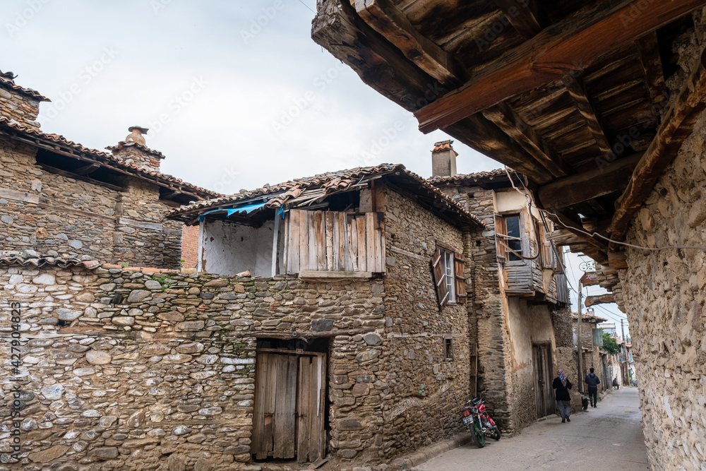 Birgi, Izmir, Turkey - 03.09.2021: wide angle view of a traditional street in Birgi village under blue sky with copy space