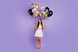 Full length photo of magnificent young lady hold hands balloons party mood shiny isolated on violet color background