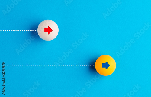 Table tennis balls are racing with each other on blue background.