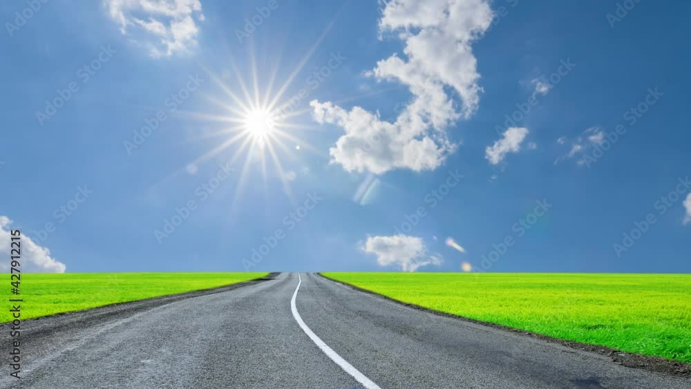 winding asphaltic road among green fields under a sparkle sun time lapse scene winding asphaltic road among green fields under a sparkle sun time lapse scene