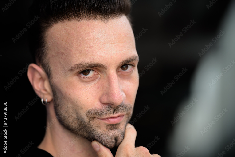 Close-up portrait of young handsome man face looking happily at camera outdoors Close-up portrait of young handsome man face looking happily at camera outdoors