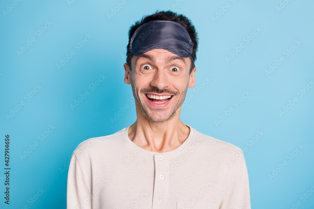 Portrait of funky cheerful mature guy wearing eye sleep mask smiling isolated over bright blue color background Portrait of funky cheerful mature guy wearing eye sleep mask smiling isolated over bright blue color background